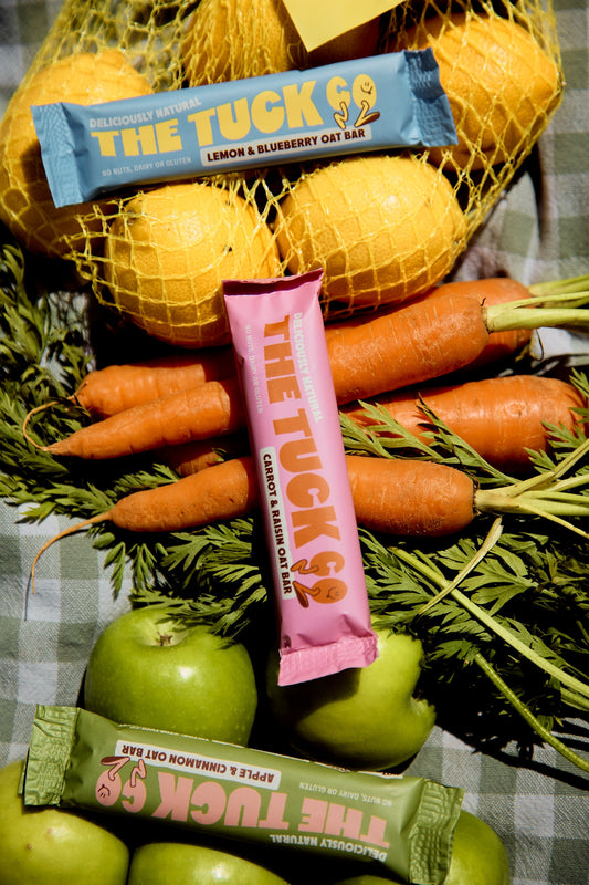 Kids snacks on a bed of lemons, carrots and apples